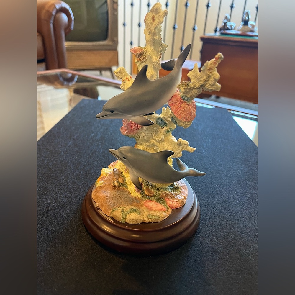 Dolphins playing on the reef sculpture by Lenox ocean beach seashore Hawaii